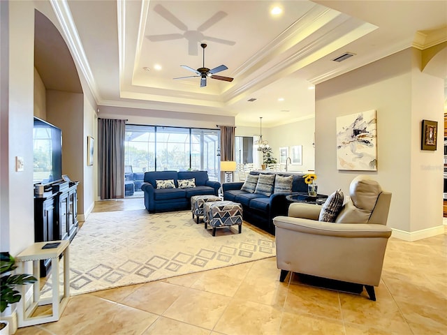 living room featuring a raised ceiling, ceiling fan, ornamental molding, and sink