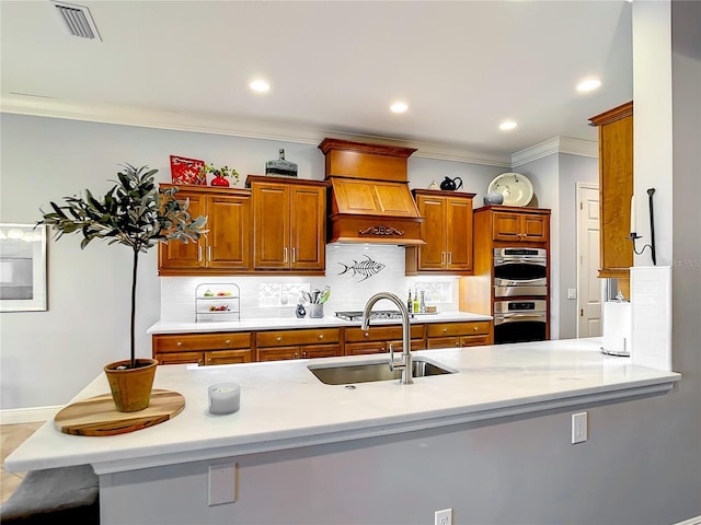 kitchen featuring a breakfast bar, crown molding, sink, custom range hood, and stainless steel appliances