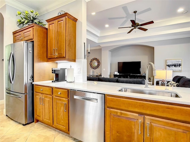 kitchen featuring ceiling fan, sink, ornamental molding, and stainless steel appliances