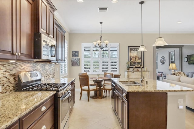 kitchen featuring an inviting chandelier, stainless steel appliances, hanging light fixtures, and tasteful backsplash