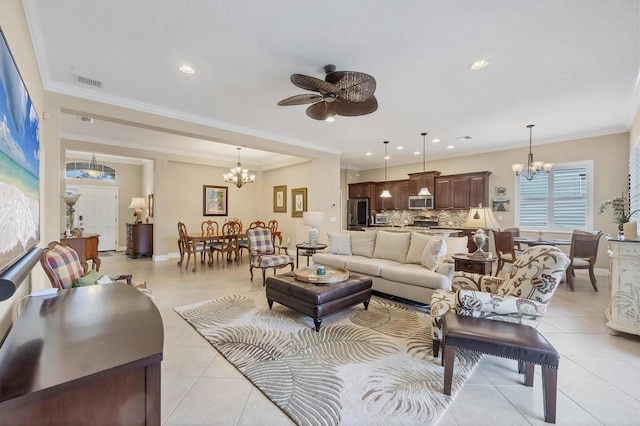 tiled living room with ceiling fan with notable chandelier and ornamental molding