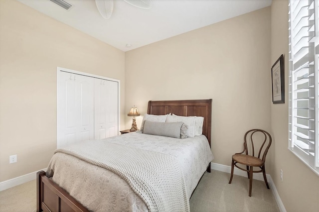 carpeted bedroom featuring ceiling fan, multiple windows, and a closet