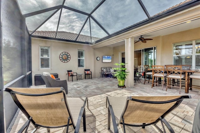 view of patio with ceiling fan and a lanai