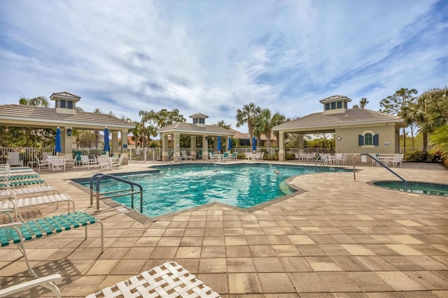 view of swimming pool featuring a hot tub and a patio area