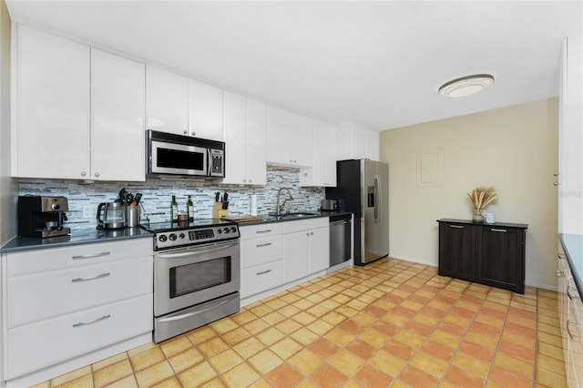 kitchen featuring backsplash, white cabinetry, sink, and appliances with stainless steel finishes