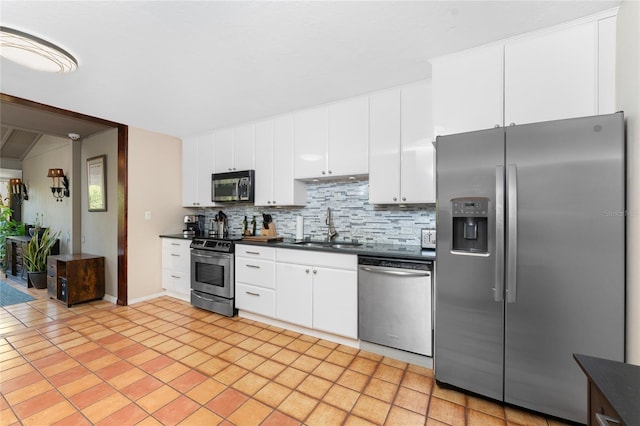 kitchen with sink, stainless steel appliances, light tile patterned floors, tasteful backsplash, and white cabinets