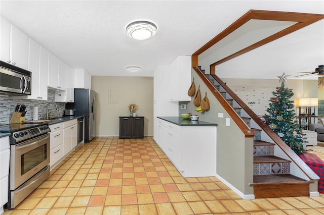 kitchen with white cabinets, appliances with stainless steel finishes, backsplash, and sink