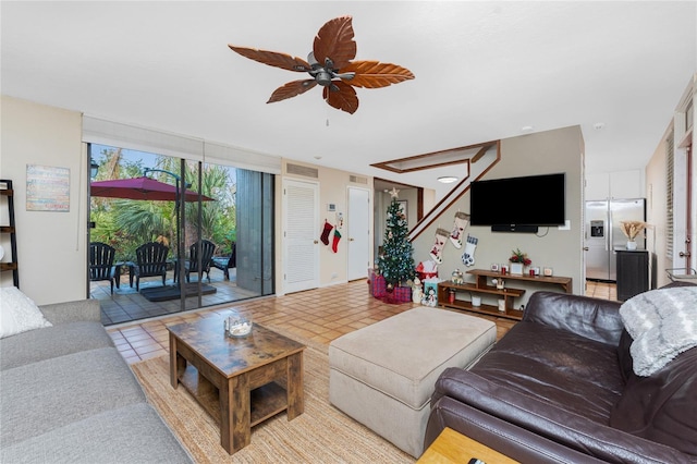 tiled living room featuring expansive windows and ceiling fan