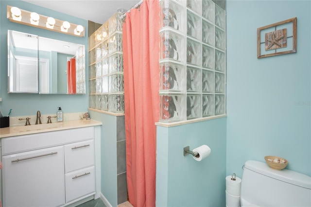 bathroom featuring vanity, toilet, and curtained shower