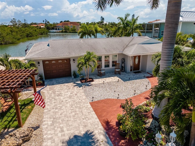 view of front of home with a pergola, a water view, and a garage