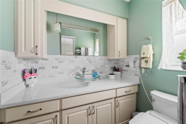 bathroom featuring tasteful backsplash, vanity, and toilet