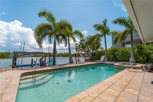 view of pool with an in ground hot tub and a water view