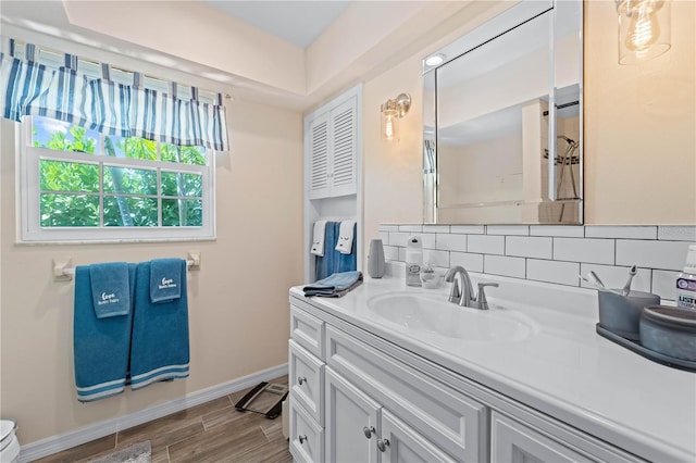 922 Casey Cove Dr, Nokomis, FL 34275 - bathroom with backsplash, baseboards, wood tiled floor, toilet, and vanity