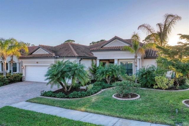 mediterranean / spanish house featuring a lawn and a garage