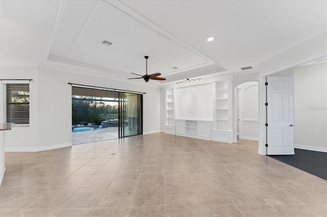 unfurnished living room with a raised ceiling, built in shelves, ceiling fan, and light tile patterned floors