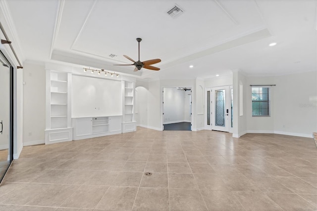 unfurnished living room featuring a tray ceiling, ceiling fan, and crown molding