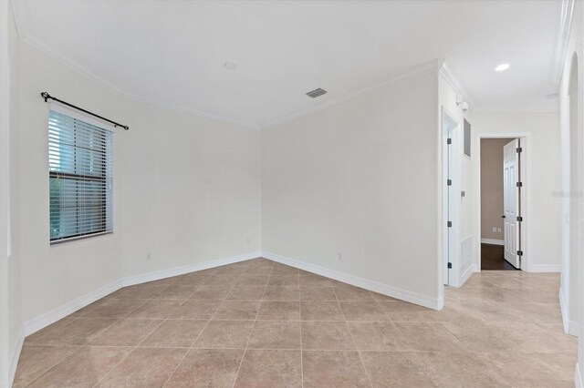 tiled spare room featuring crown molding