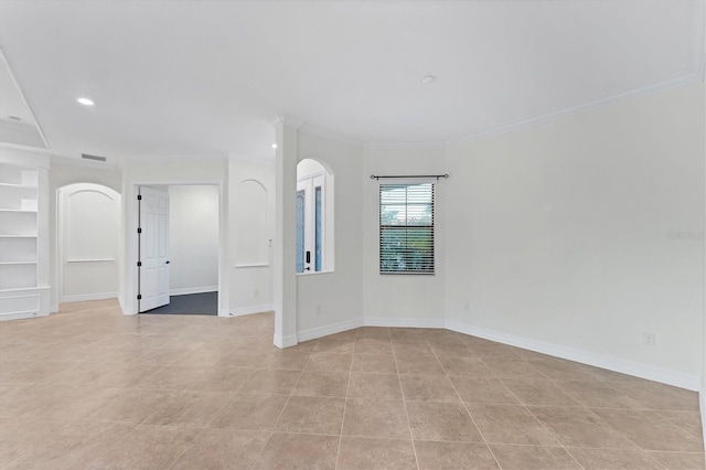 empty room featuring light tile patterned flooring and ornamental molding