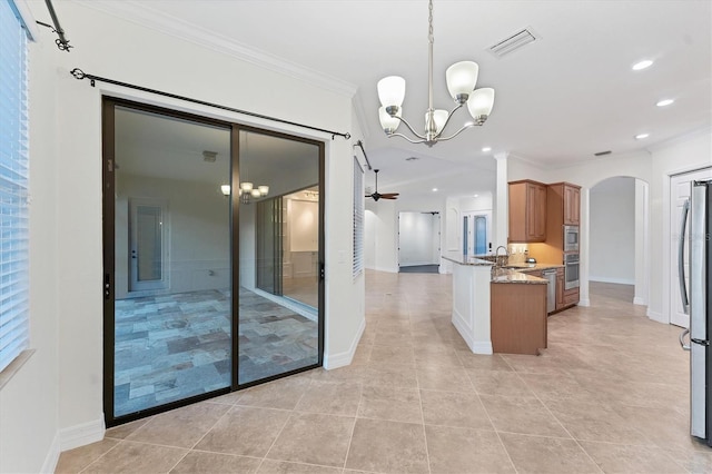 kitchen featuring ceiling fan with notable chandelier, light stone counters, kitchen peninsula, and crown molding