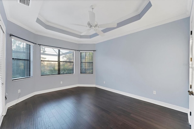 unfurnished room featuring dark hardwood / wood-style flooring, a tray ceiling, ceiling fan, and ornamental molding