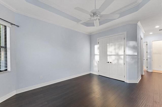 foyer entrance with a raised ceiling, ceiling fan, dark hardwood / wood-style flooring, and crown molding