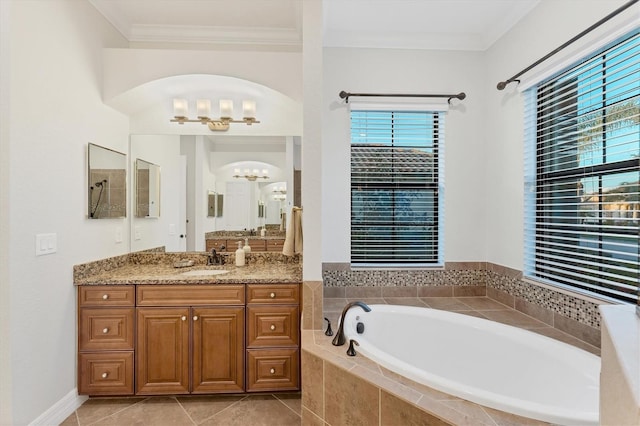 bathroom featuring tile patterned floors, vanity, crown molding, a relaxing tiled tub, and an inviting chandelier