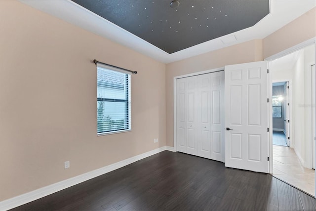 unfurnished bedroom featuring dark hardwood / wood-style floors and a closet