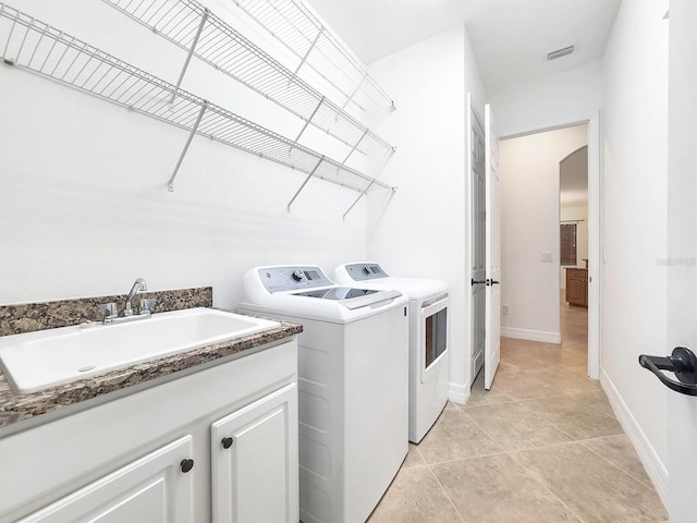 laundry area with washing machine and clothes dryer, sink, and light tile patterned flooring