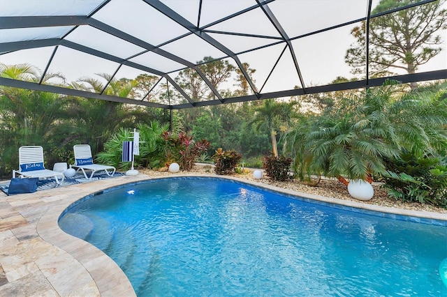 view of pool featuring glass enclosure and a patio area