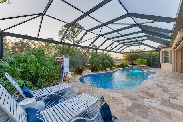 view of swimming pool with pool water feature, glass enclosure, and a patio area