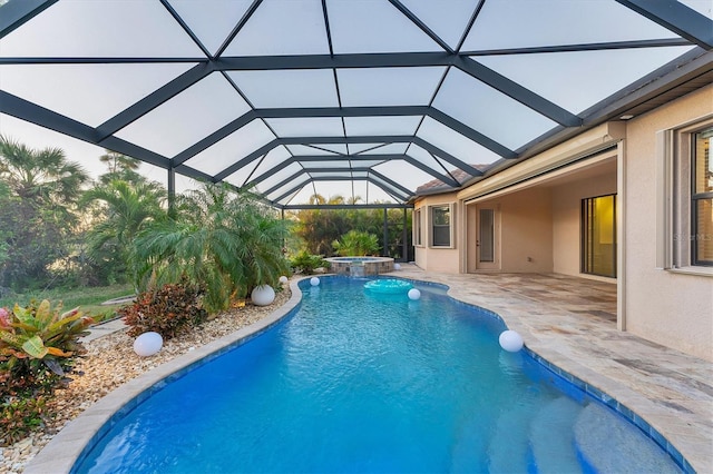 view of swimming pool with glass enclosure, an in ground hot tub, and a patio