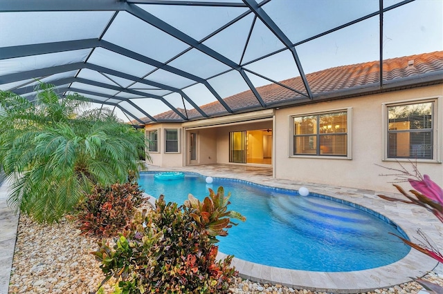 view of swimming pool with glass enclosure and a patio area