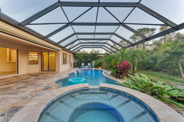 view of pool with an in ground hot tub, a patio area, and a lanai