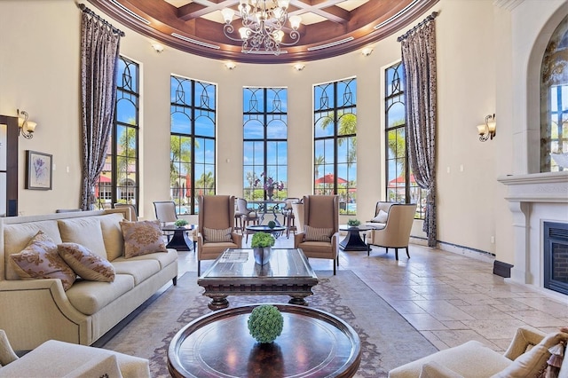 living room featuring beam ceiling, coffered ceiling, crown molding, a towering ceiling, and a chandelier