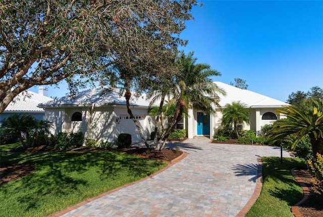 view of front of house with a garage and a front lawn