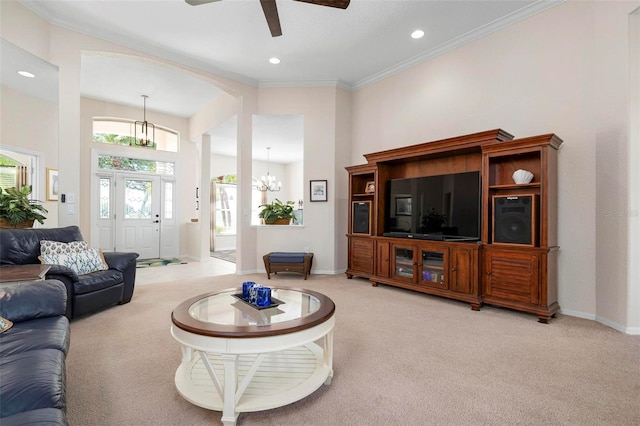 living room featuring crown molding, light colored carpet, and ceiling fan with notable chandelier