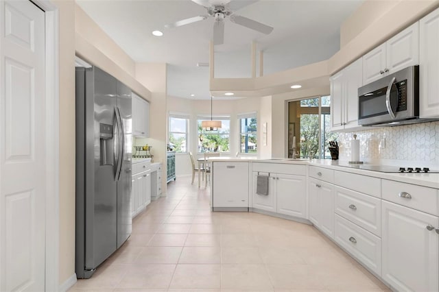 kitchen with white cabinets, plenty of natural light, light tile patterned floors, and appliances with stainless steel finishes