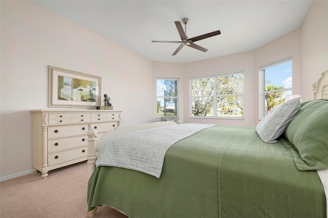 carpeted bedroom featuring multiple windows and ceiling fan