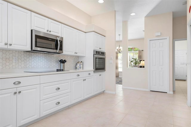 kitchen featuring white cabinets, backsplash, light tile patterned flooring, and stainless steel appliances