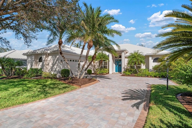 mediterranean / spanish home featuring a front yard and a garage