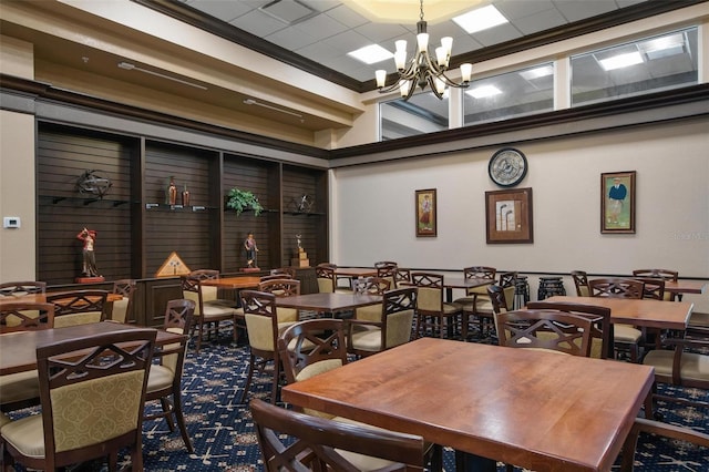 dining area with a high ceiling, an inviting chandelier, and ornamental molding