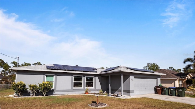 single story home with solar panels, a garage, and a front lawn