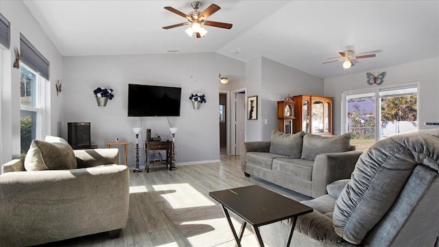 living room featuring plenty of natural light, ceiling fan, vaulted ceiling, and light hardwood / wood-style flooring