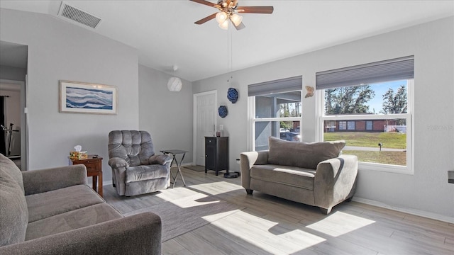 living room with light hardwood / wood-style floors, ceiling fan, and lofted ceiling