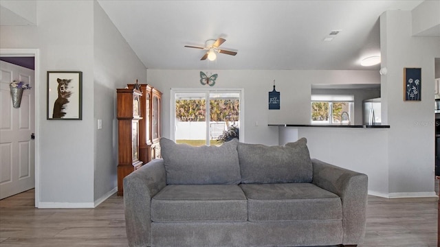 living room featuring ceiling fan, light wood-type flooring, and sink