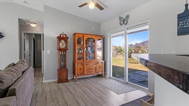 dining space with a mountain view, light hardwood / wood-style floors, vaulted ceiling, and ceiling fan