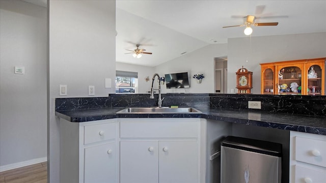 kitchen with vaulted ceiling, ceiling fan, sink, wood-type flooring, and white cabinetry