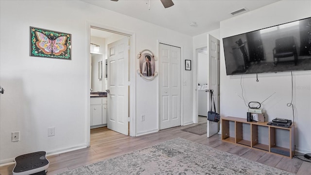 bedroom featuring ceiling fan, light hardwood / wood-style floors, and ensuite bathroom