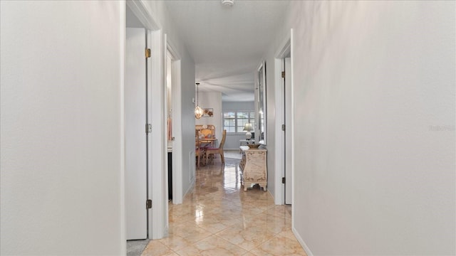 corridor with an inviting chandelier