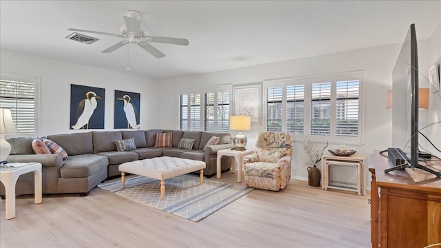 living room with ceiling fan, plenty of natural light, and light hardwood / wood-style floors